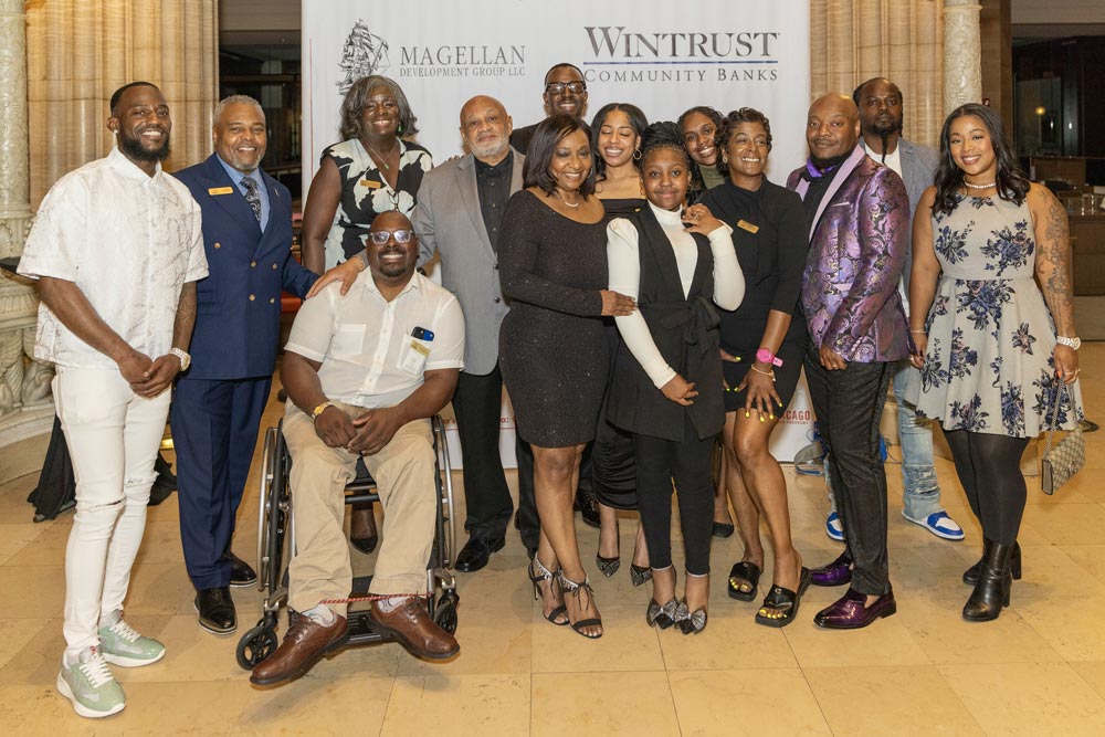 Large group in front of the sponsor signage