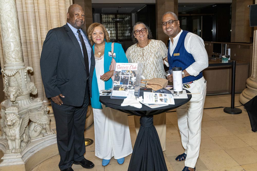 Four guests standing behind a high table