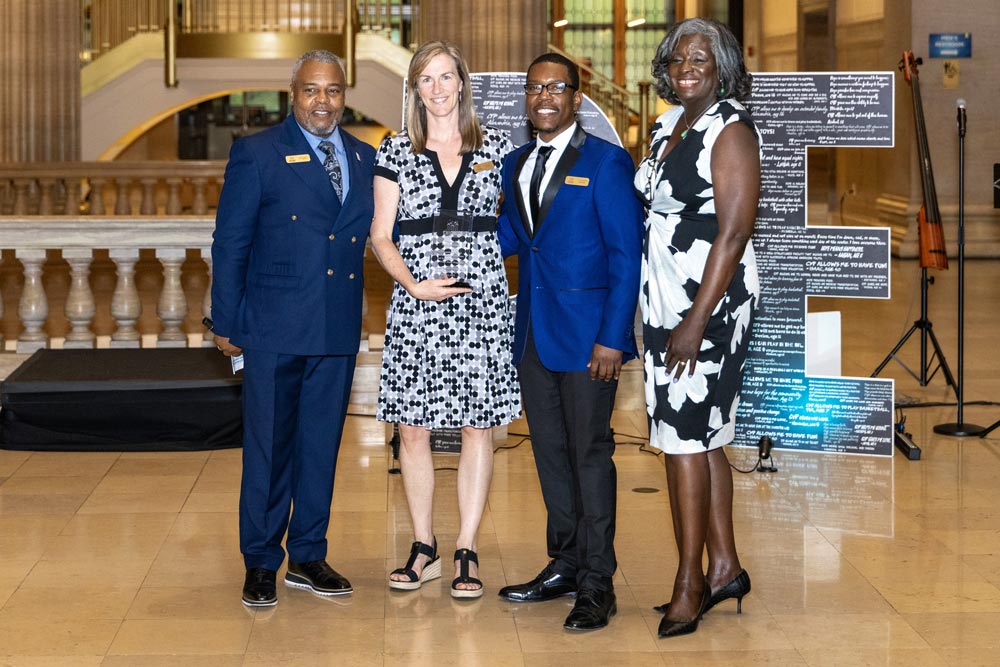 Three members of CYP staff with an awardee
