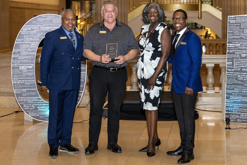 Three members of CYP staff with an awardee